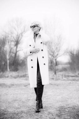 Beyaz kürklü kadın ceketi, leopar atkısı, kedi gözü gözlükleri, sarışın hoş bayan portresi, moda konsept.