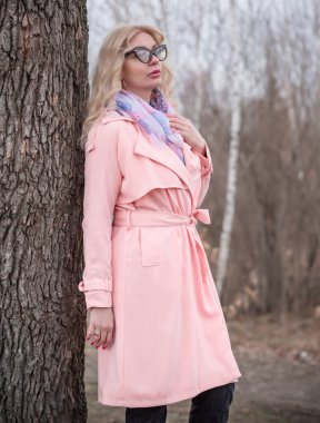 Pembe ceketli kadın, leylak atkı, kedi gözü gözlüğü, sarışın hoş bayan portresi, modaya uygun konsept.