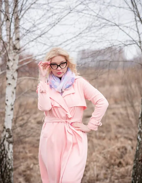 Woman in pink coat jacket , lilac scarf, cat eye glasses, portrait of blonde nice lady, trendy concept