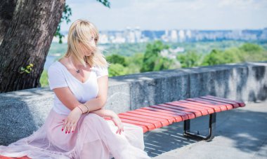 Şık giyinen genç sarışın kadın şehir sokaklarında yürüyor, şık bir bayan, moda. Artı sokaktaki boy modeli.