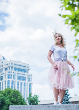 Şık giyinen genç sarışın kadın şehir sokaklarında yürüyor, şık bir bayan, moda. Artı sokaktaki boy modeli.