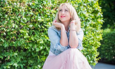 Şık giyinen genç sarışın kadın şehir sokaklarında yürüyor, şık bir bayan, moda. Artı sokaktaki boy modeli.