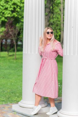 Büyük bedenli, Amerikan ya da Avrupa görünümlü mutlu bir kadın şehirde hayatın tadını çıkarıyor. Aşırı kilolu genç bir bayan, şehir parkında şık giyinmiş. Doğal güzellik.