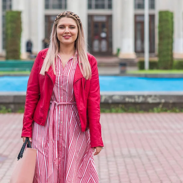 Happy woman of plus size, American or European appearance walks in the city enjoying life. Young lady with excess weight, stylishly dressed at the city park .Natural beauty