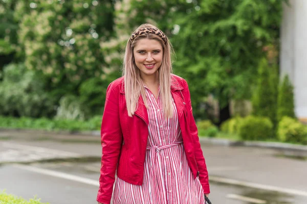 Happy woman of plus size, American or European appearance walks in the city enjoying life. Young lady with excess weight, stylishly dressed at the city park .Natural beauty