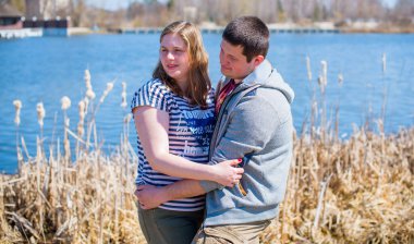 Artı parkta yürüyen çift bedenli aşıklar. Genç bir adam ve şişman bir çift tatilde.