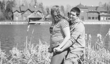 Artı parkta yürüyen çift bedenli aşıklar. Genç bir adam ve şişman bir çift tatilde.