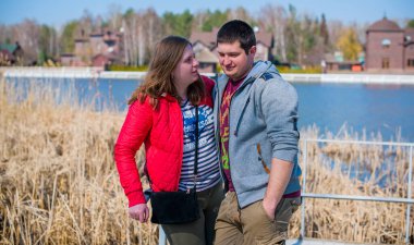 Artı parkta yürüyen çift bedenli aşıklar. Genç bir adam ve şişman bir çift tatilde.