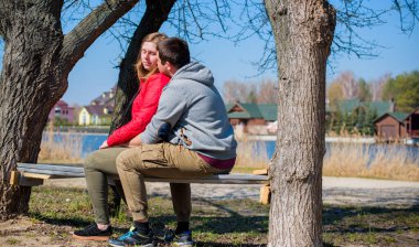Artı parkta yürüyen çift bedenli aşıklar. Genç bir adam ve şişman bir çift tatilde.