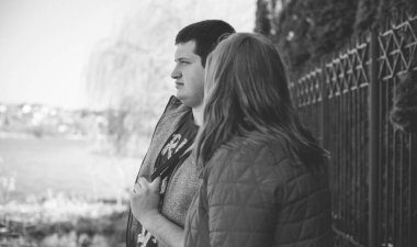 Artı parkta yürüyen çift bedenli aşıklar. Genç bir adam ve şişman bir çift tatilde.