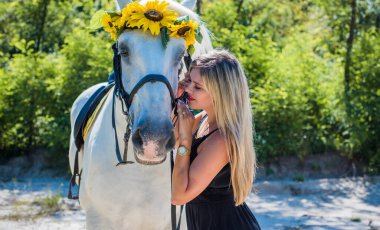 Kırsalda bir atı olan hoş bir Amerikalı kız. Güzel bir binici ve at. At çiftliğinde sanat fotoğrafçılığı. Sonbaharda kırsal alanda ata binen çekici bir kız.
