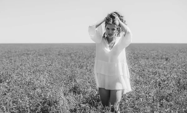 Özgürlük kavramı. Yeşil tarlada genç, mutlu bir kadın, akşam ışığı. Arkadaki mavi gökyüzü. Güzel kız doğanın tadını çıkarıyor. Beyaz elbiseli güzel bir genç kız çayırda koşuyor.