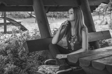 Sonbahar, doğa ve insan kavramı. Sırt çantalı güzel bir kadın sonbahar parkında dinleniyor. Oldukça iyi bir kadın gezgin rahatlar. Dağları sevmek, konsept macera açık havada aktif tatiller