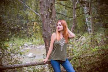 Sonbahar, doğa ve insan kavramı. Sırt çantalı güzel bir kadın sonbahar parkında dinleniyor. Oldukça iyi bir kadın gezgin rahatlar. Dağları sevmek, konsept macera açık havada aktif tatiller