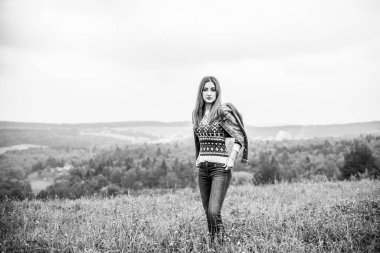 Sonbahar, doğa ve insan kavramı. Sırt çantalı güzel bir kadın sonbahar parkında dinleniyor. Oldukça iyi bir kadın gezgin rahatlar. Dağları sevmek, konsept macera açık havada aktif tatiller