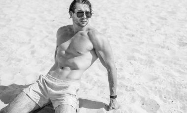 Plajda taş gibi vücudu olan kaslı, genç ve atletik bir adam. Güçlü ve yakışıklı. Deniz kıyısındaki genç Avrupalı adamın portresi..