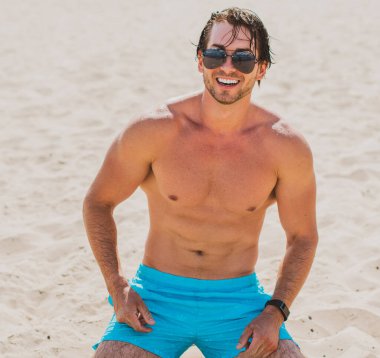 Plajda taş gibi vücudu olan kaslı, genç ve atletik bir adam. Güçlü ve yakışıklı. Deniz kıyısındaki genç Avrupalı adamın portresi..