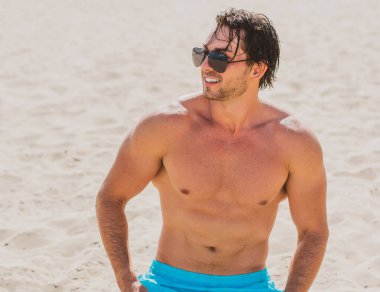 Plajda taş gibi vücudu olan kaslı, genç ve atletik bir adam. Güçlü ve yakışıklı. Deniz kıyısındaki genç Avrupalı adamın portresi..