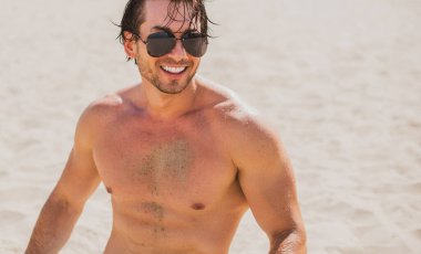 Plajda taş gibi vücudu olan kaslı, genç ve atletik bir adam. Güçlü ve yakışıklı. Deniz kıyısındaki genç Avrupalı adamın portresi..