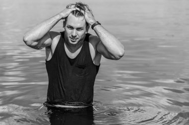 Plajda taş gibi vücudu olan kaslı, genç ve atletik bir adam. Güçlü ve yakışıklı. Deniz kıyısındaki genç Avrupalı adamın portresi..