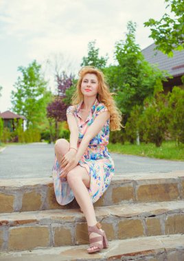 Kadın doğal olarak dinleniyor. Tatil ya da hafta sonu kavramı. Genç ve şık bayan dışarıda dinleniyor. İyi ve romantik bir ruh hali. Hayatı ve eğlenceyi sev. Hayatın parçaları.