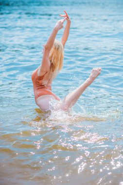 Suda aerobik yapan genç bir kadın, egzersizler, sağlık hayatı konsepti.