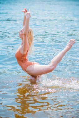 Suda aerobik yapan genç bir kadın, egzersizler, sağlık hayatı konsepti.