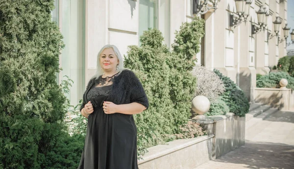 Woman of plus size, American or European appearance walks at the city enjoying life. A young lady with excess weight, xl size at the center of the city. Natural beauty