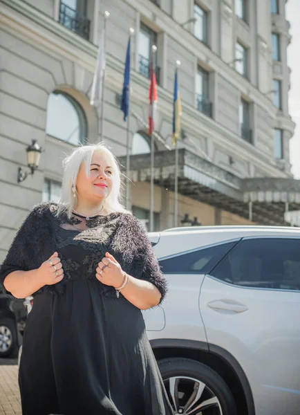 Woman of plus size, American or European appearance walks at the city enjoying life. A young lady with excess weight, xl size at the center of the city. Natural beauty