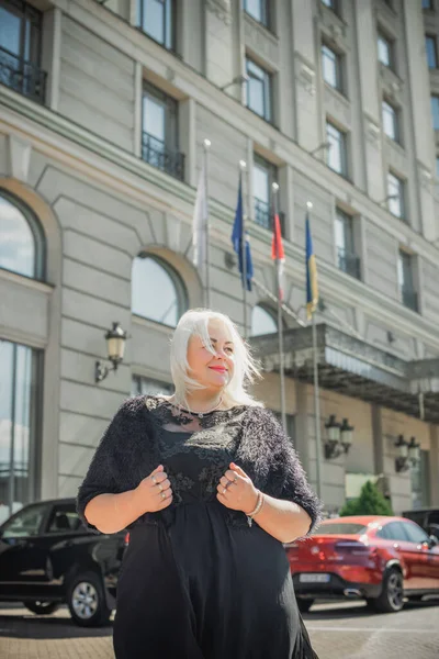 Woman of plus size, American or European appearance walks at the city enjoying life. A young lady with excess weight, xl size at the center of the city. Natural beauty