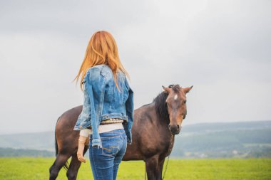 Kırsal kesimde bir bayan bir atla yürüyor. Dışarıda atı olan genç ve güzel bir kadın. At binicisi, ata binen kadın