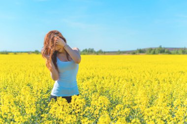 Özgürlük kavramı. Yeşil tarladaki genç mutlu kadın. Arkadaki mavi gökyüzü. Güzel kız doğanın tadını çıkarıyor. Çayırda güzel bir kız