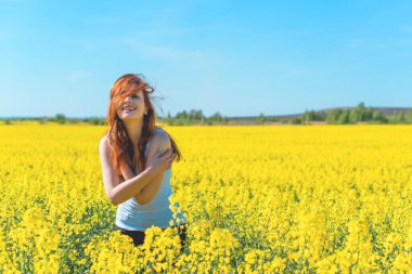 Özgürlük kavramı. Yeşil tarladaki genç mutlu kadın. Arkadaki mavi gökyüzü. Güzel kız doğanın tadını çıkarıyor. Çayırda güzel bir kız