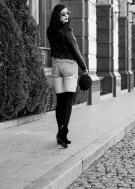 Güzel ve şık esmer kadın güneşli bir günde şehirde yürüyor, modern gündelik tarzda.