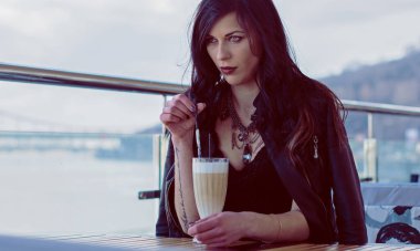 Güzel ve şık esmer kadın güneşli bir günde şehirde yürüyor, modern gündelik tarzda.