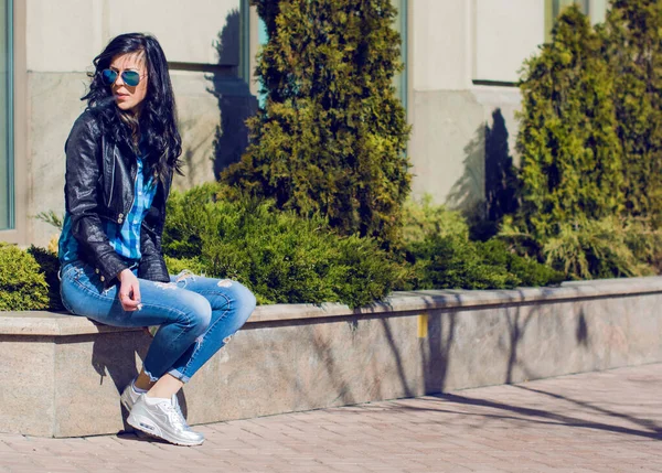 Esmer Kadın Mavi Gömlekli Kot Pantolonlu Şehirde Sigara Içiyor — Stok fotoğraf