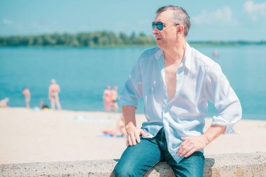 Olgun bir Avrupalı adam, açık havada dinlenirken çekilmiş bir portresi var. 50 yıl sonra yaşam konsepti