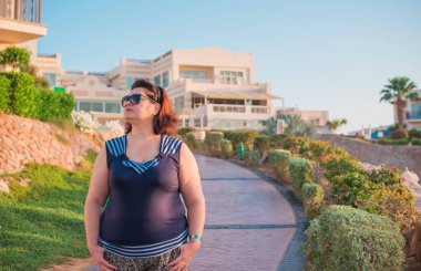 Ayrıca doğada orta yaşlı bir Amerikalı kadın, hayatın tadını çıkar, sahilde yürü. İnsanların hayatı XXL boyutunda, mutlu, güzel, olgun bir bayan.