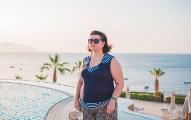 Ayrıca doğada orta yaşlı bir Amerikalı kadın, hayatın tadını çıkar, sahilde yürü. İnsanların hayatı XXL boyutunda, mutlu, güzel, olgun bir bayan.