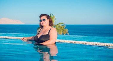  Ayrıca Mısır 'da havuzda orta yaşlı bir kadın, tatil ve rahatlama konsepti, Afrika' ya seyahat.