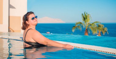  Ayrıca Mısır 'da havuzda orta yaşlı bir kadın, tatil ve rahatlama konsepti, Afrika' ya seyahat.