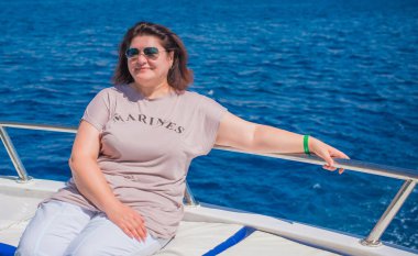  Ayrıca Mısır 'da yatta orta yaşlı bir kadın. Tatil ve rahatlama konsepti. Afrika' ya seyahat.