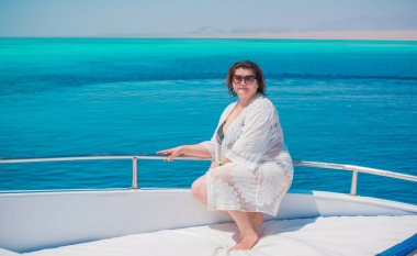  Ayrıca Mısır 'da yatta orta yaşlı bir kadın. Tatil ve rahatlama konsepti. Afrika' ya seyahat.