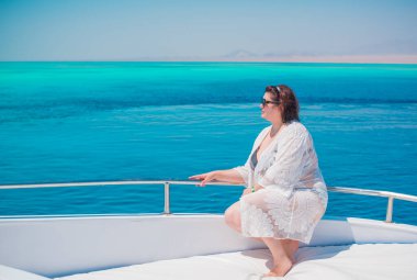  Ayrıca Mısır 'da yatta orta yaşlı bir kadın. Tatil ve rahatlama konsepti. Afrika' ya seyahat.