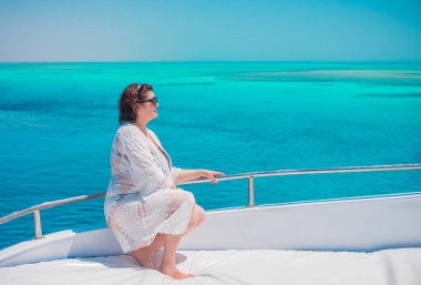  Ayrıca Mısır 'da yatta orta yaşlı bir kadın. Tatil ve rahatlama konsepti. Afrika' ya seyahat.