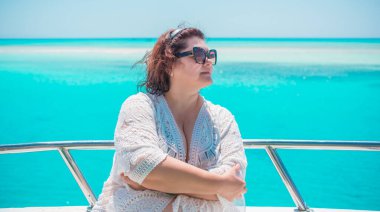  Ayrıca Mısır 'da yatta orta yaşlı bir kadın. Tatil ve rahatlama konsepti. Afrika' ya seyahat.