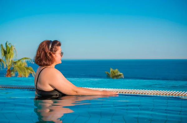 Plus size middle age woman in pool at Egypt, vacation and relax concept, travel to Africa