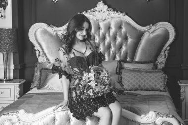 Viktorya dönemi tarzı iç mimarisi olan oldukça görkemli bir kadın yatak odasında, dantelli kısa elbise giymiş. Kadınlık ve çekicilik kavramı