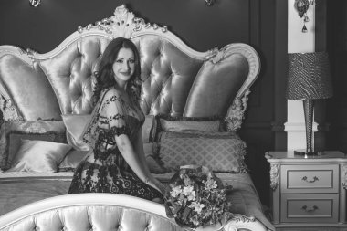 Viktorya dönemi tarzı iç mimarisi olan oldukça görkemli bir kadın yatak odasında, dantelli kısa elbise giymiş. Kadınlık ve çekicilik kavramı