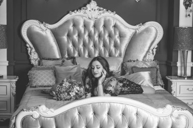 Viktorya dönemi tarzı iç mimarisi olan oldukça görkemli bir kadın yatak odasında, dantelli kısa elbise giymiş. Kadınlık ve çekicilik kavramı